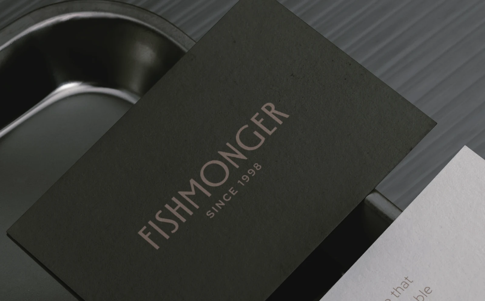 The Fishmonger wordmark on a dark green card